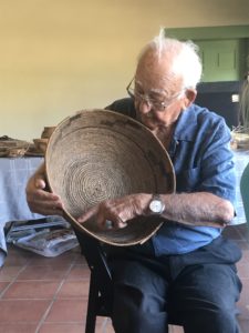 Ipay Elder Justin Farmer assesses a basket brought by a visitor to the lecture.